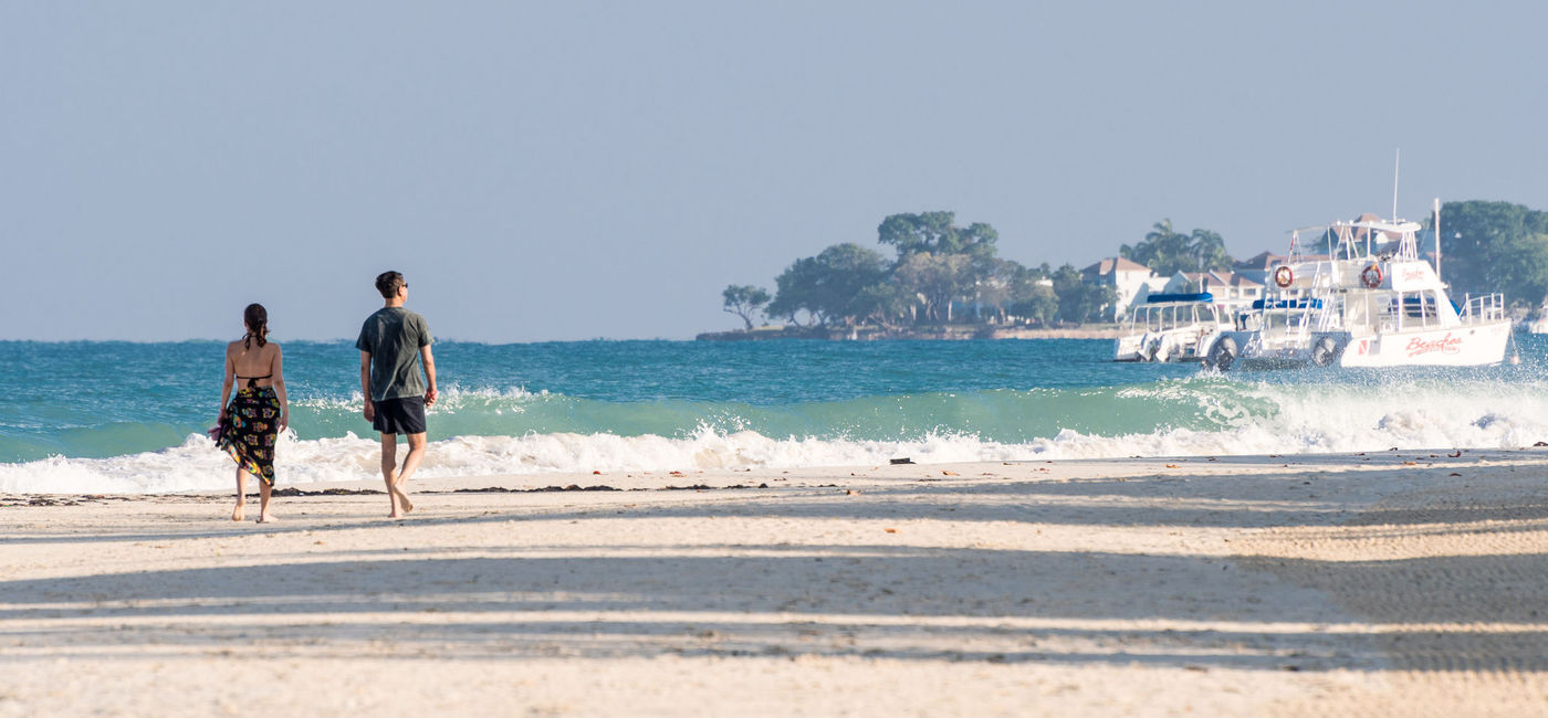 Image: Couple walking Seven Mile Beach in Negril, Jamaica. (photo via Debbie Ann Powell/iStock Editorial/Getty Images Plus)
