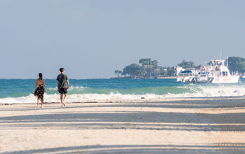 Couple walking Seven Mile Beach in Negril, Jamaica