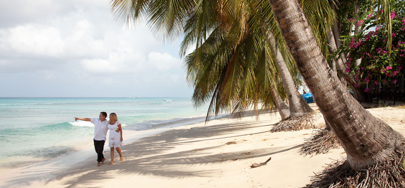 Image: PHOTO: Couple walking on the beach in Barbados. (photo via boophotography/iStock/Getty Images Plus)