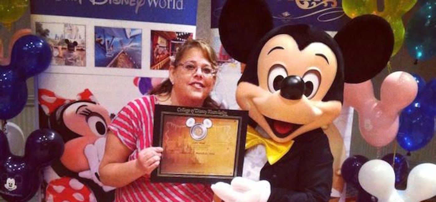 Image: PHOTO: Travel agent Lori Wall being lauded by Mickey Mouse himself. (photo courtesy of Lori Wall)