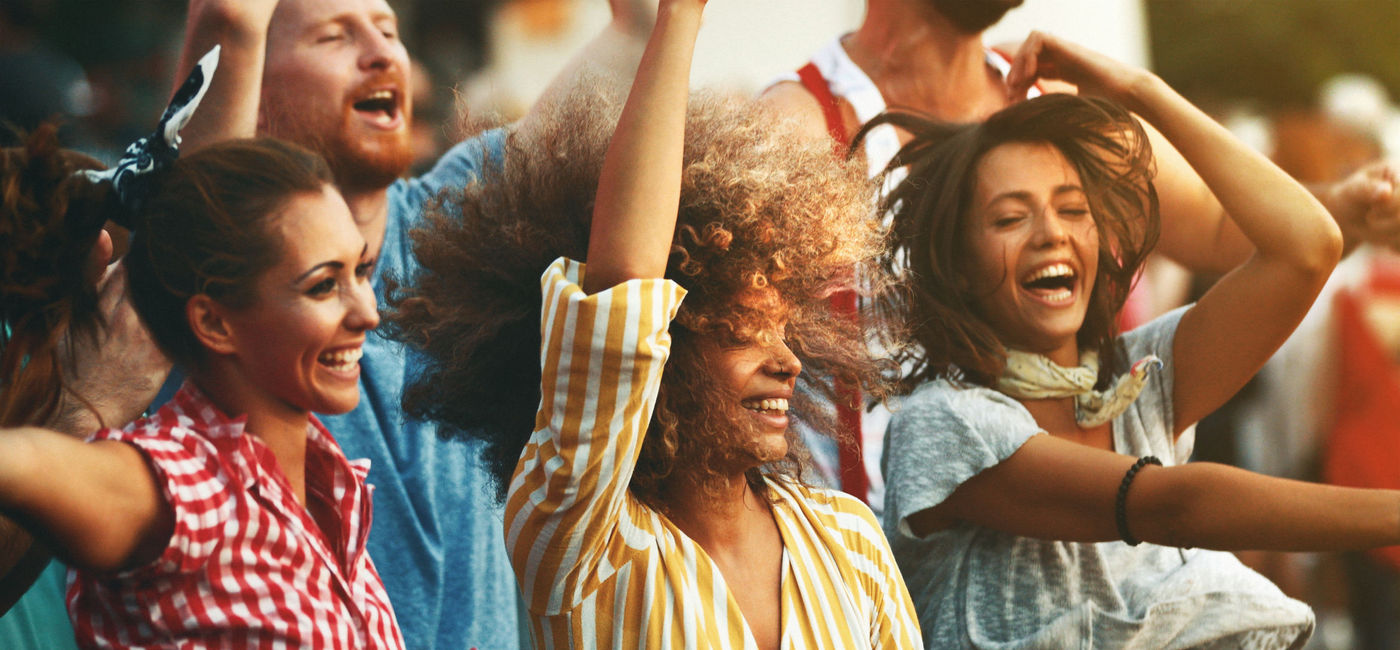 Image: Group of friends dancing at a concert. (photo via iStock/E+/gilaxia)