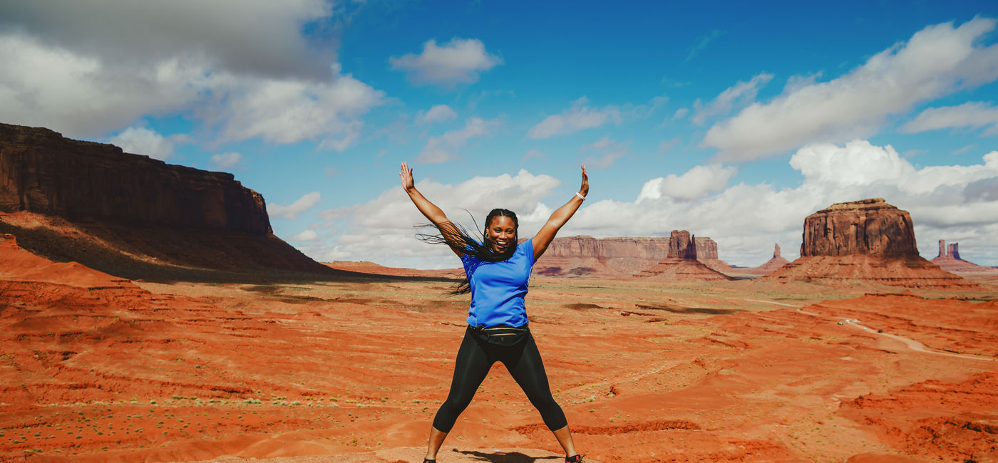 Image: A woman on an Intrepid Travel trip poses in front of Monument Valley, Arizona. (photo via Intrepid Group) ((photo via Intrepid Group))