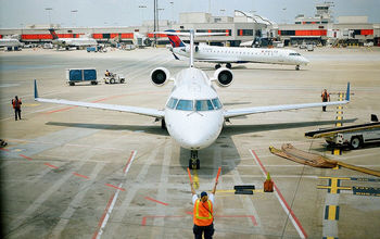 Airport worker directs a plane