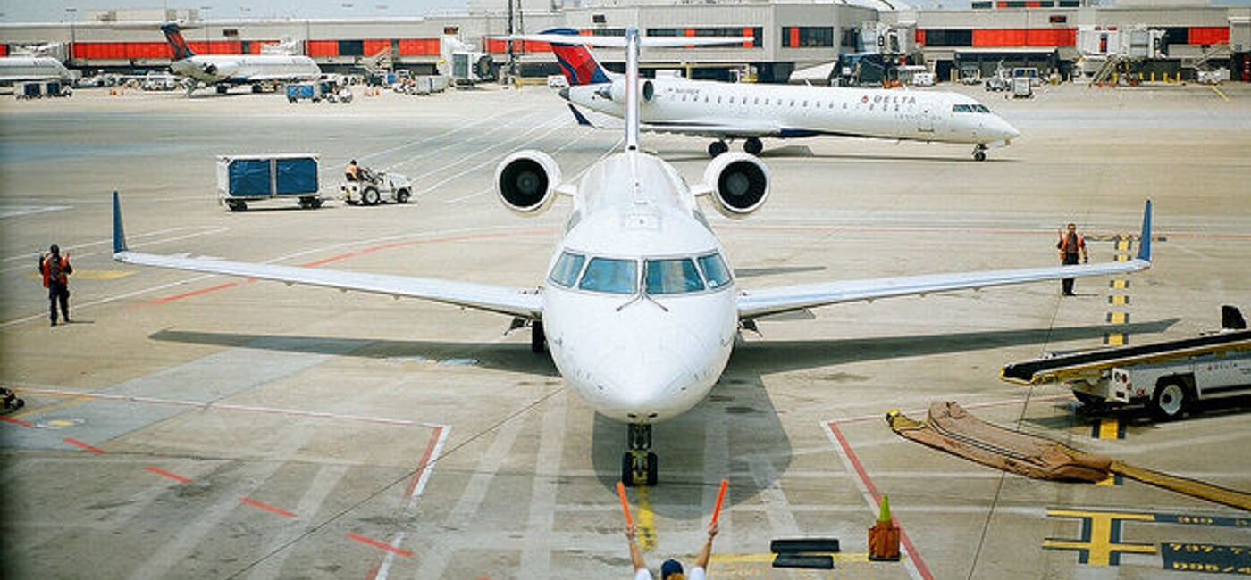 Image: PHOTO: Airport worker directs a plane. (photo via Flickr/Steve Snodgrass)