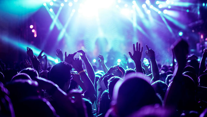 Crowd raising their hands at concert (Photo via bernardbodo / iStock / Getty Images Plus)