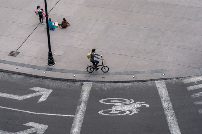 Man cycling through Zocalo Square in Mexico City Man cycling through Zocalo Square in Mexico City