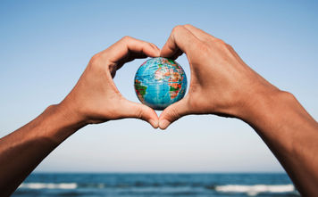 A young man with a world globe in his hands
