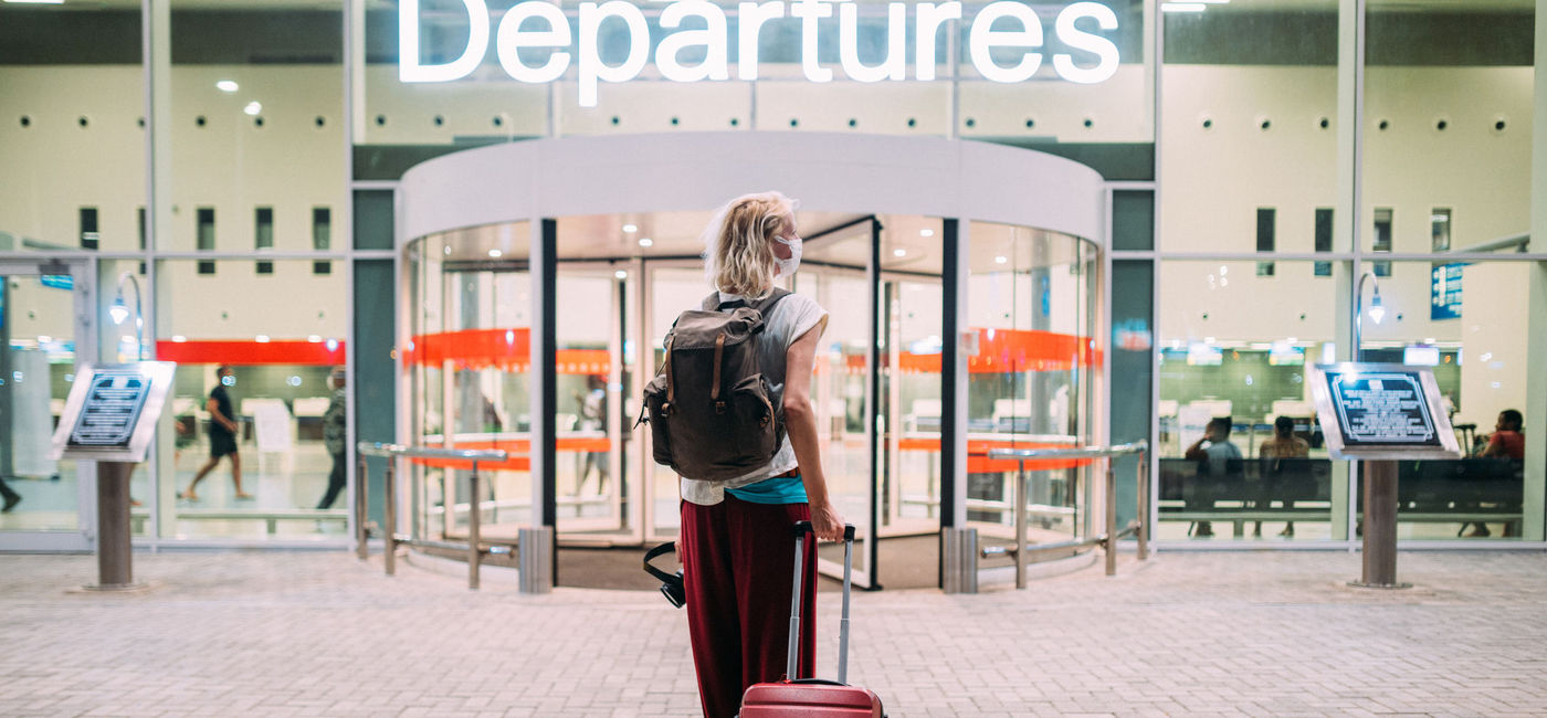 Image: Young woman heading toward her departure gate at the airport. (photo via iStock/Getty Images E+/Pyrosky)
