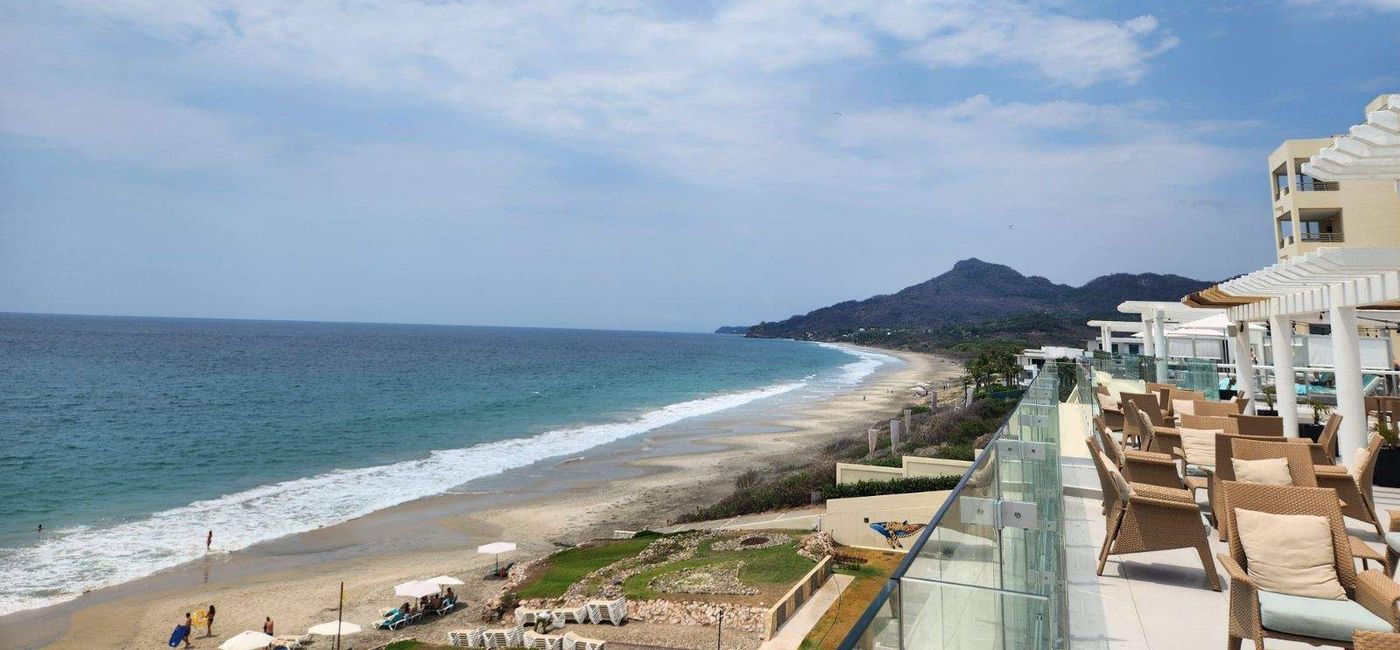 Image: The coastline of the resort, featuring the Pacific Ocean and the Sierra Madre Occidental mountain range. (Photo Credit: Jennifer Sayles)