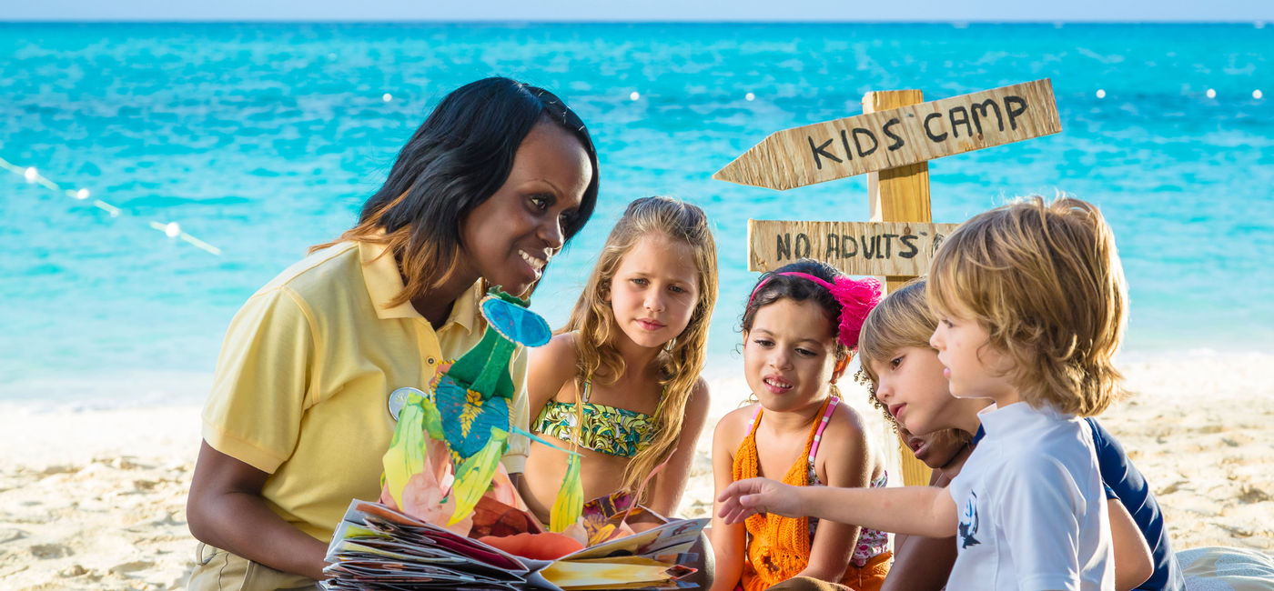 Image: A Beaches Resorts childcare worker with autism certification from IBCCES spends time with five young children on the beach. (photo via Beaches Resorts) ((photo via Beaches Resorts))