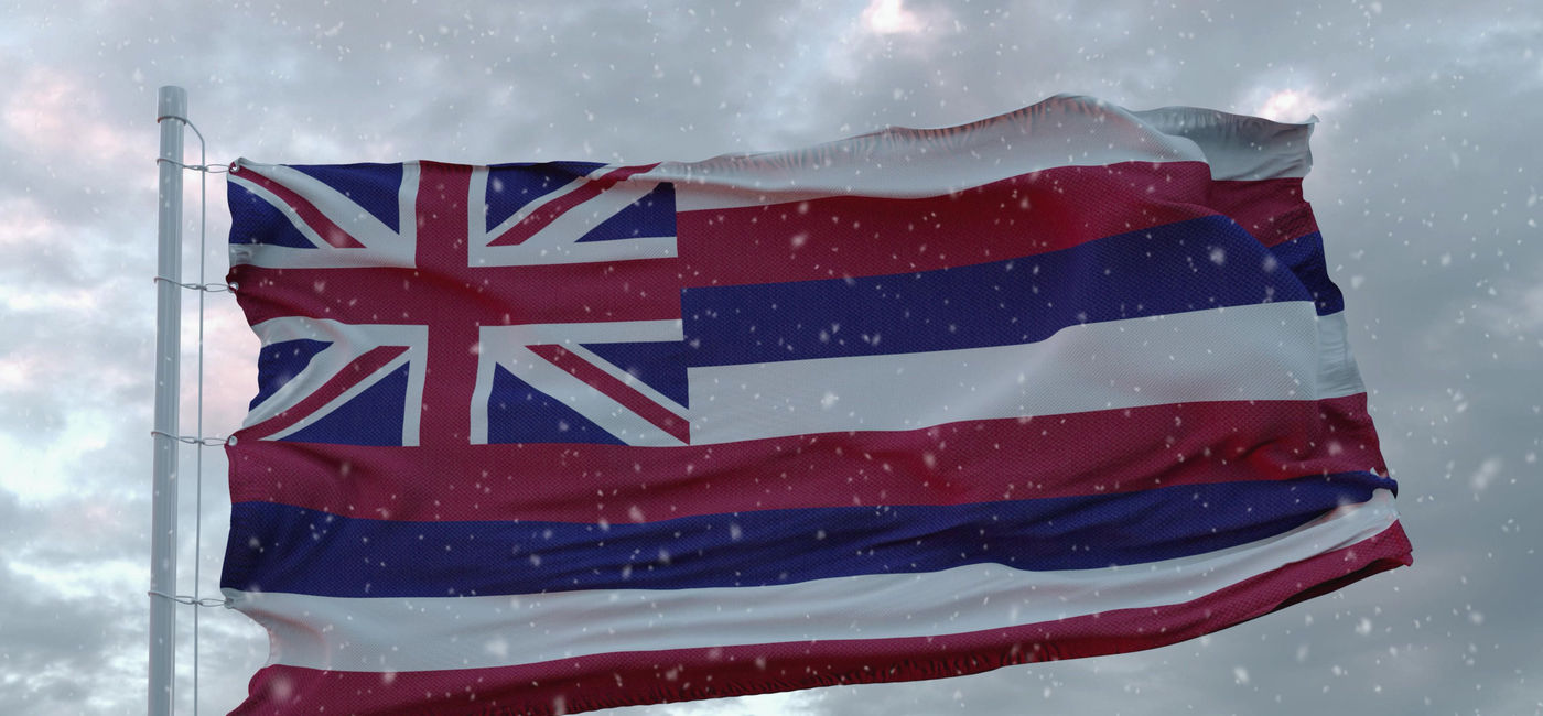 Image: Hawaii's state flag amid falling snowflakes. (photo via iStock/Getty Images Plus/Dmitry Larichev)