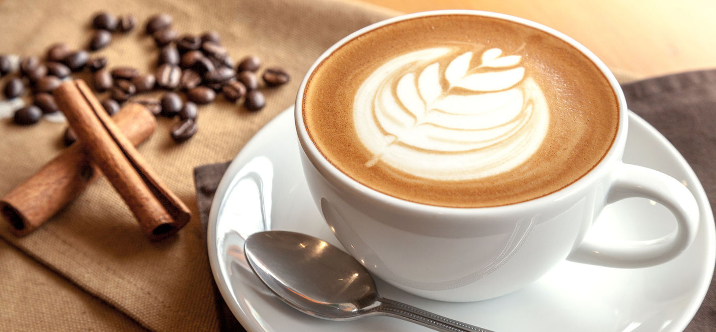 Image: PHOTO: Cafe latte with coffee beans and cinnamon sticks. (Photo via iStock/Getty Images Plus/yktr)