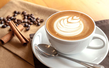 Cafe latte with coffee beans and cinnamon sticks.