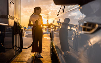Woman refueling her car at gas station.