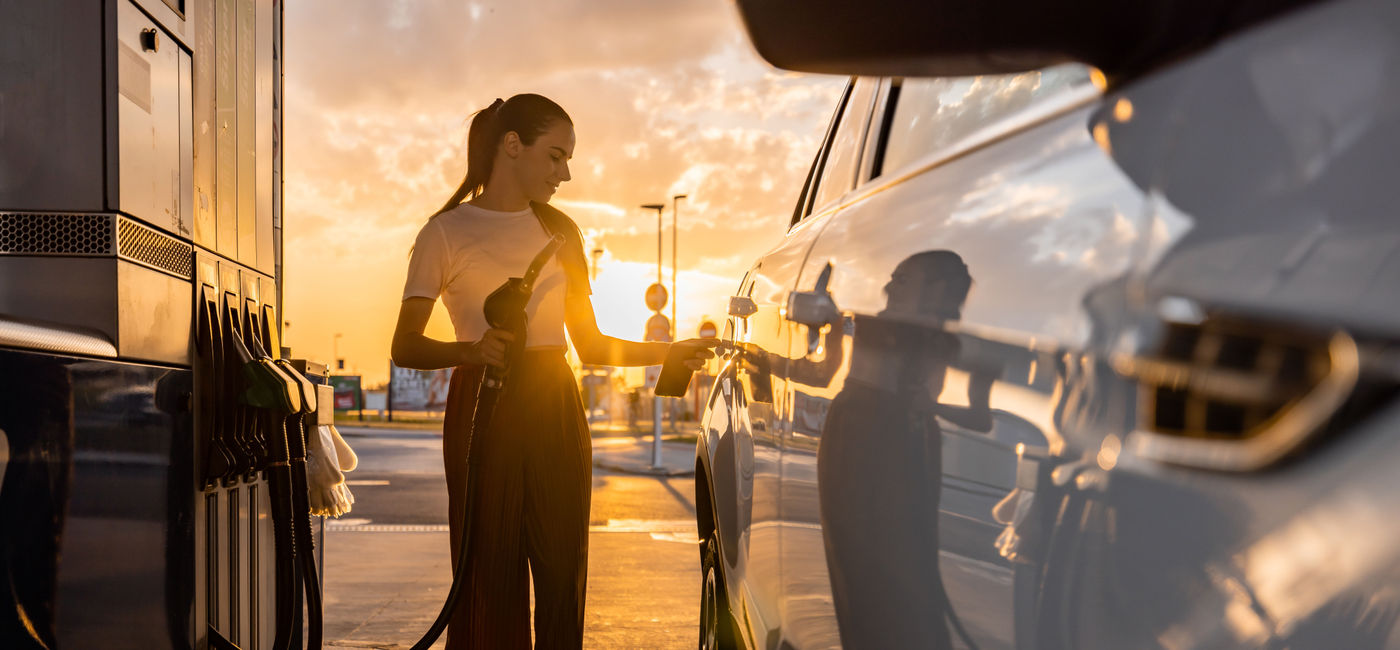 Image: Woman refueling her car at gas station. (Photo Credit: SimonSkafar / E+)
