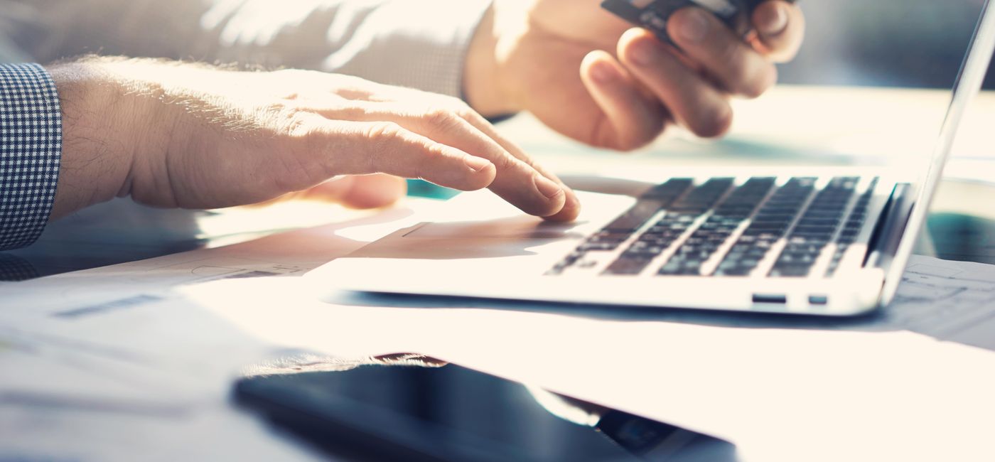 Image: Man on laptop with credit card. (Photo via Pinkypills / iStock / Getty Images Plus)