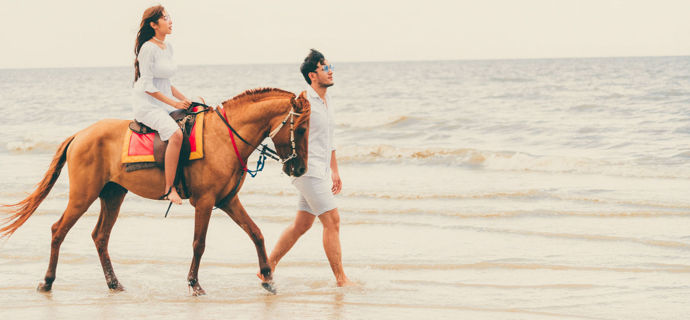 Image: Couple horseback riding in Jamaica. (photo courtesy of NanoStockk/iStock/Getty Images Plus)