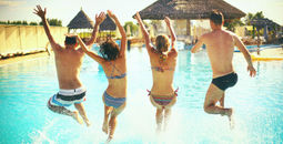 Group jumping into pool at an all-inclusive resort.