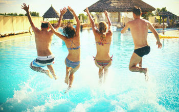 Group jumping into pool at an all-inclusive resort.