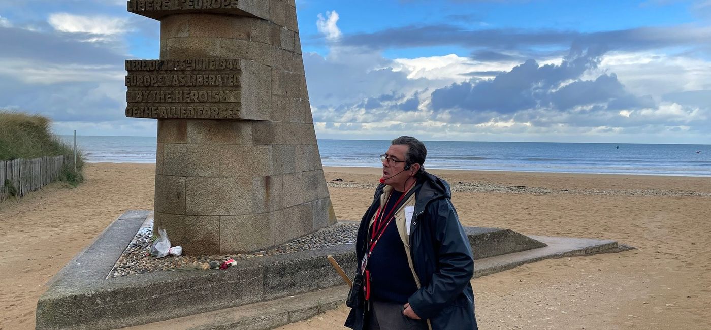 Image: A Viking guide paying tribute to the troops at a D-Day landing site. (Bruce Parkinson)
