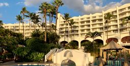 White resort hotel Fairmont Kea Lani during sunset with view of blue resort pool.