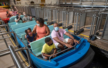 Disney guests on ride with masks.