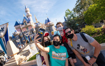 Guests in front of Sleeping Beauty's Castle at Disneyland Park.