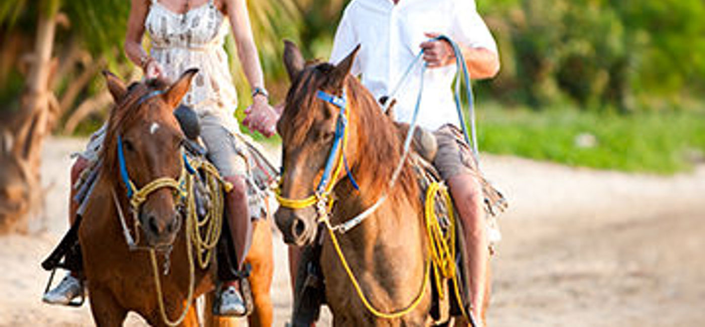 Image: PHOTO: A couple enjoying a Couples Resorts horseback tour along a Jamaican beach. (photo courtesy of Couples Resorts)
