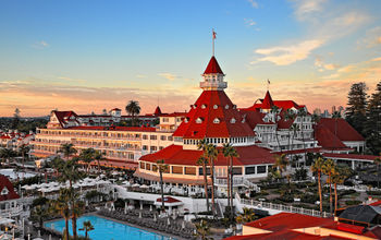 Exterior view of victorian hotel with red roof and swimming pool