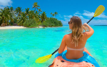 Woman kayaking during her vacation in the Cook Islands. 