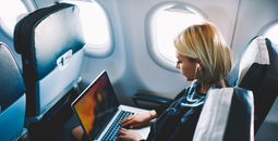 Woman using wi-fi during plane flight.