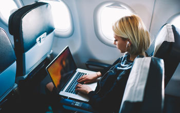 Woman using wi-fi during plane flight.