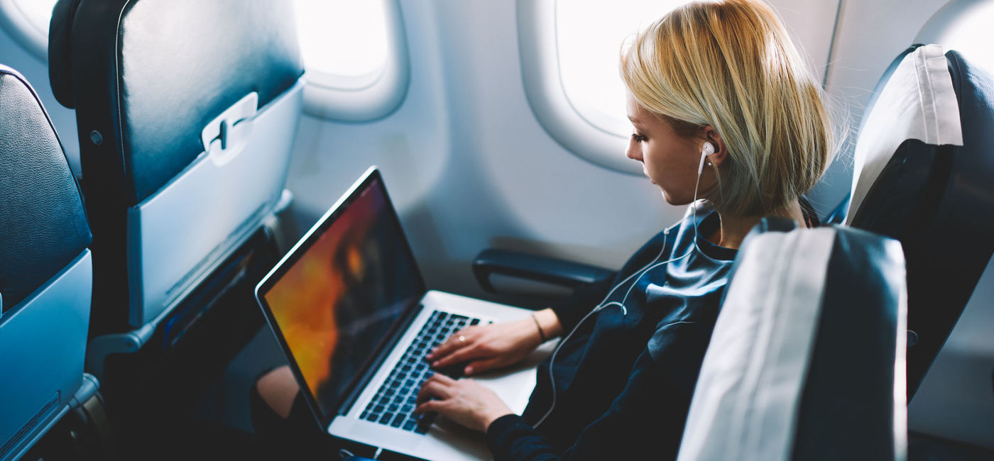 Image: Woman using wi-fi during plane flight. (photo via GaudiLab / iStock / Getty Images Plus)