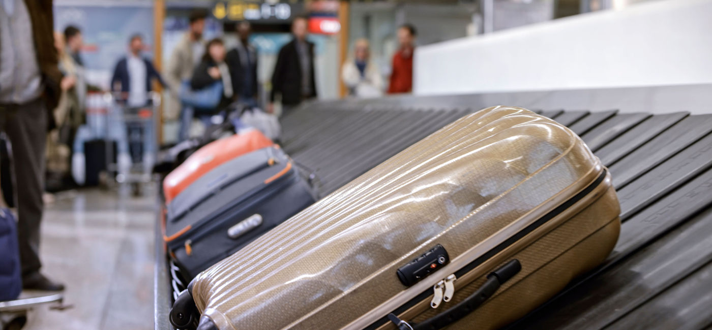 Image: PHOTO: Business people standing at baggage claim. (photo via simonkr / E+)