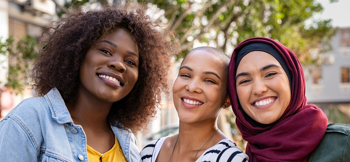 Image: A group of women smile at the camera. (photo via  iStock / Getty Images Plus /  Ridofranz)