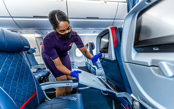 Delta flight attendant cleaning on board.