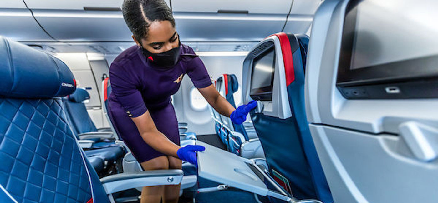 Image: PHOTO: Delta flight attendant cleaning on board. (photo via Delta Air Lines Media)