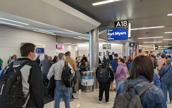 Airport crowd gathers at gate to board flight