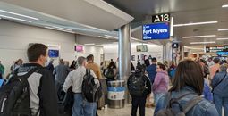 Airport crowd gathers at gate to board flight