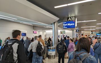 Airport crowd gathers at gate to board flight