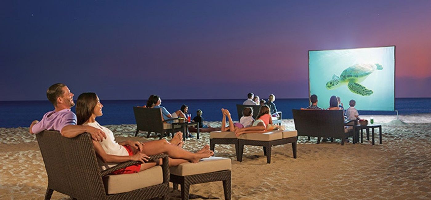 Image: PHOTO: Guests watching a movie under the stars at Dreams Los Cabos Suites Golf Resort & Spa. (photo via AMResorts)