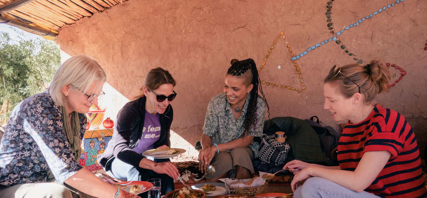 Image: A tour group has tea and pastries at Association Tawesna as part of an Intrepid impact initiative experience. (photo via Shu Lin / Intrepid Travel) ((photo via Shu Lin / Intrepid Travel))