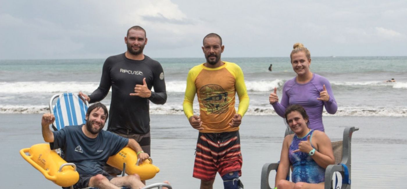 Image: Travelers on a Wheel the World group trip pose on a beach in Costa Rica with Wheel the World's Co-Founder and CEO, Alvaro Silberstein, sitting on the left. (photo via Wheel the World) ((photo via Wheel the World))