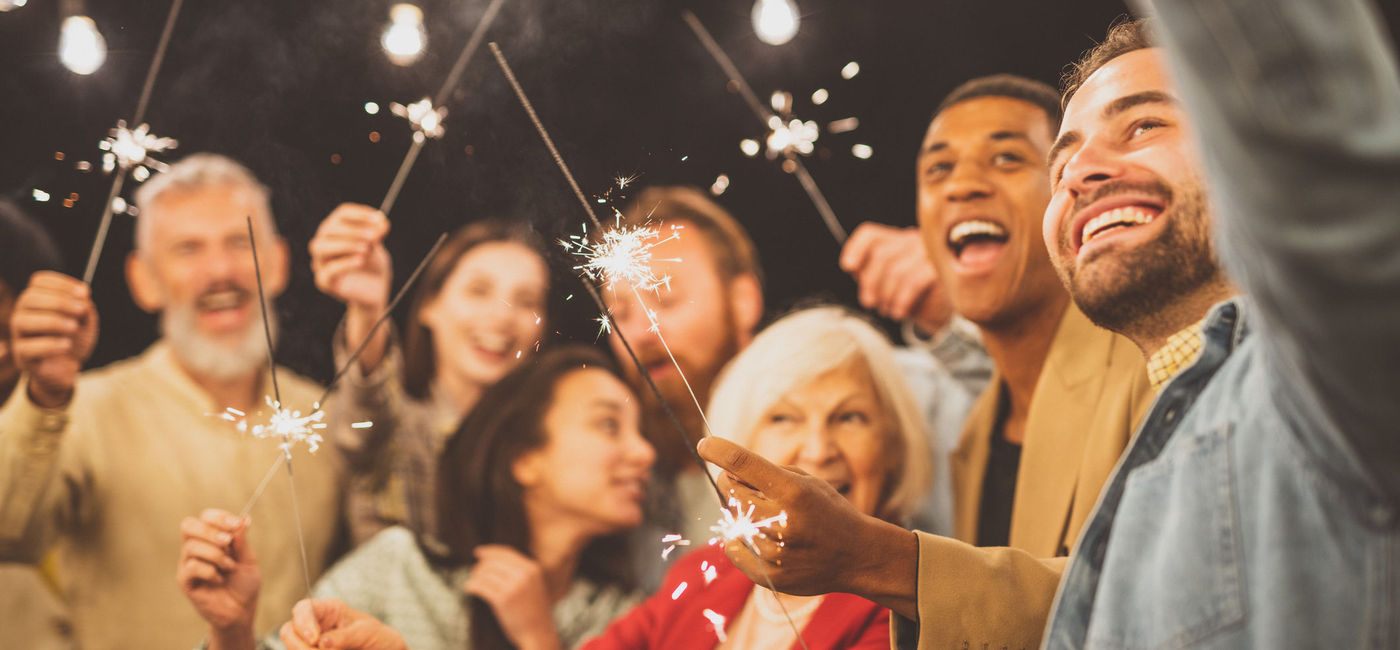 Image: Family and friends celebrating New Year's Eve. (photo via Diamond Dogs / iStock / Getty Images Plus)