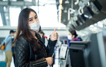 Young woman wearing a mask at airport check-in.