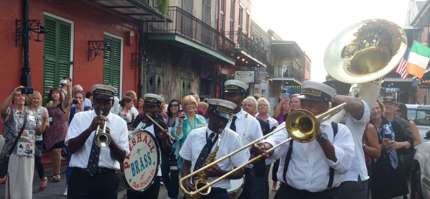 Image: PHOTO: The Preservation Hall Band marches through the streets of New Orleans' French Quarter. (photo by Monica Poling)