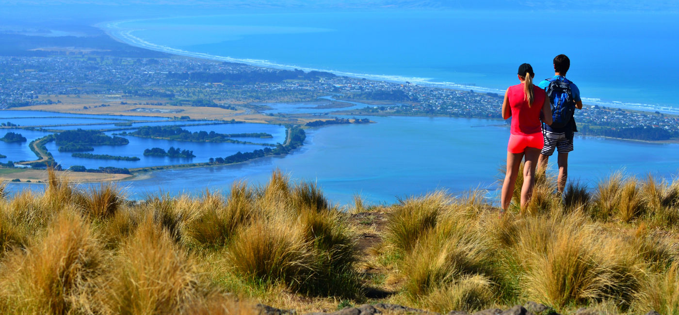 Image: PHOTO: Couple look at the landscape view of Christchurch, New Zealand. (photo via chameleonseye/iStock/Getty Images Plus)