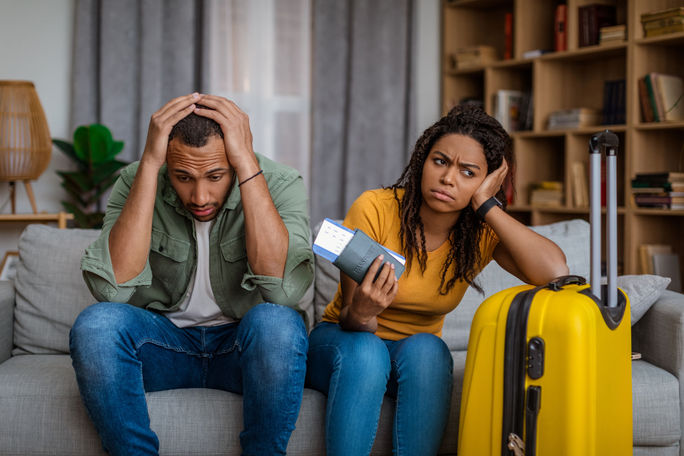 Travelers frustrated with prolonged passport processing wait times. travelers, couple, customers, passports, processing, documents, frustrated, sad, upset, waiting, luggage