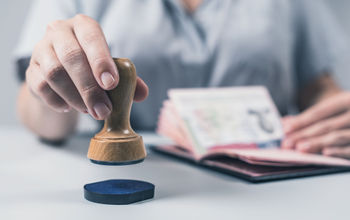 Customs and Immigration Control officer stamping a passport.