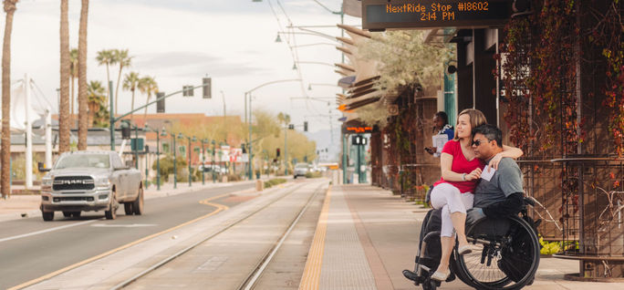 A couple waits for an accessible bus in Mesa, Arizona. Wheel the World, wheelchair, accessibility, accessible destinations, Mesa, Visit Mesa, destination verified, bus stop